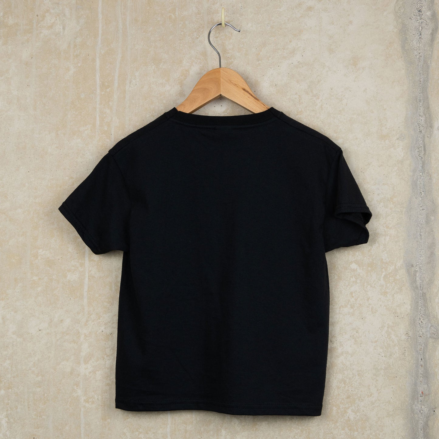 the back of Black cotton child's t-shirt with Falmouth, Cornwall around six skull crossbones
