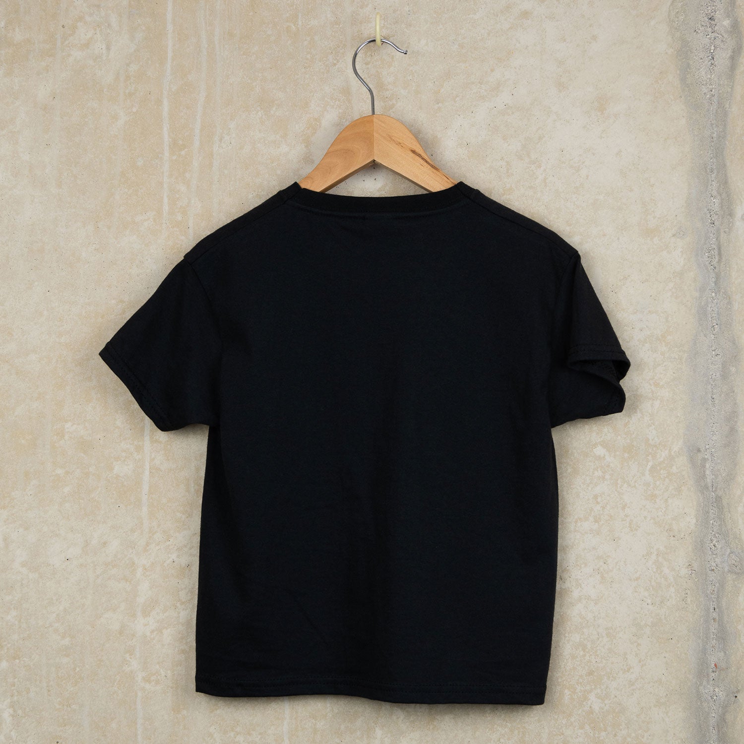 the back of Black cotton child's t-shirt with Falmouth, Cornwall around six skull crossbones