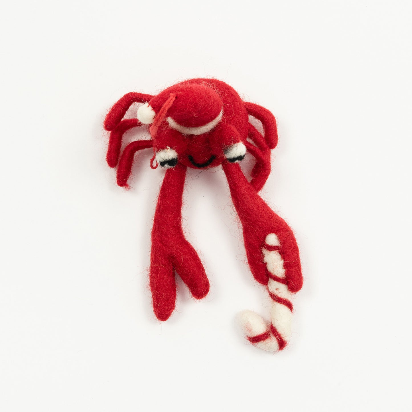A Christmas crab decoration pictured on a white background. The felt crab is red and is wearing a Christmas hat.