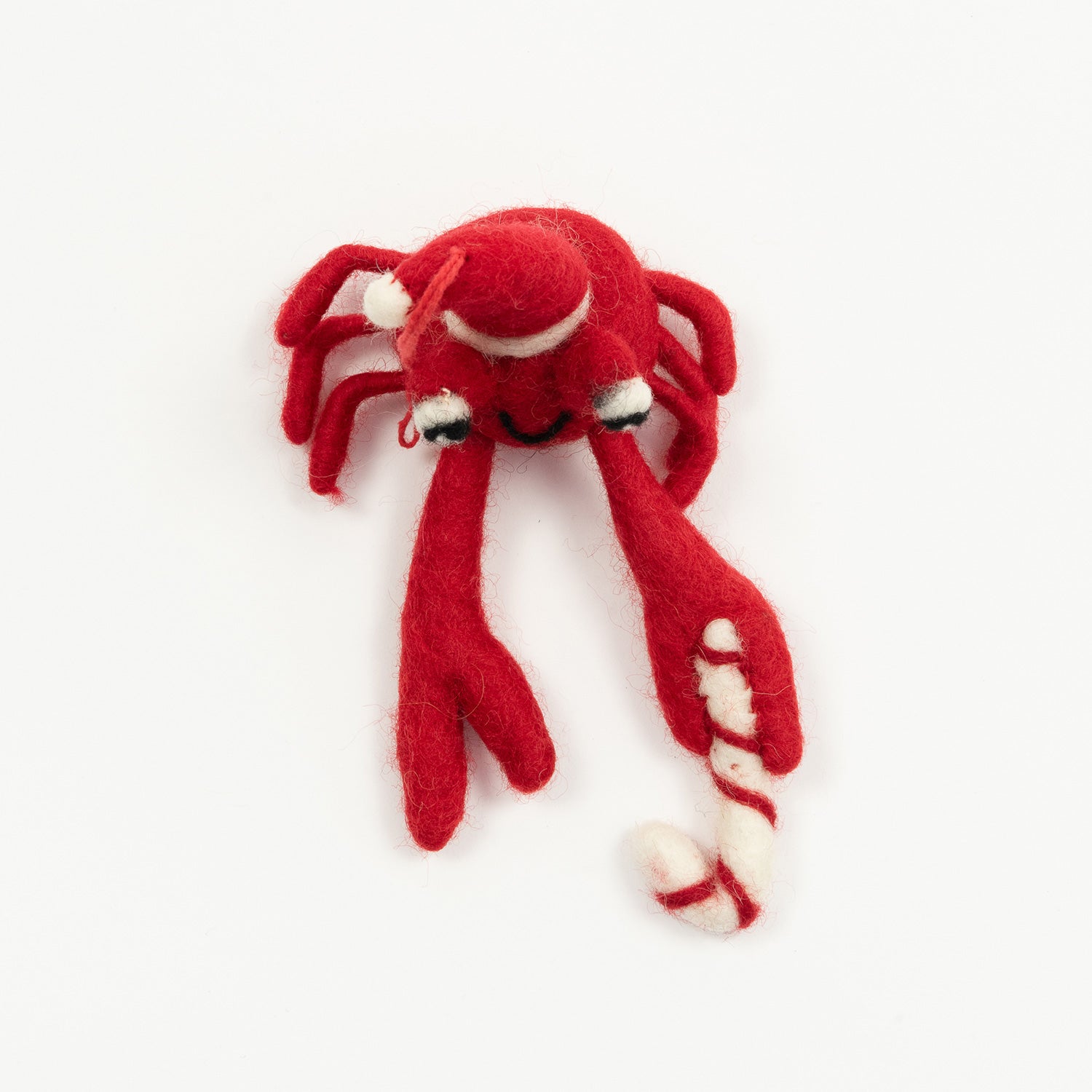 A Christmas crab decoration pictured on a white background. The felt crab is red and is wearing a Christmas hat.