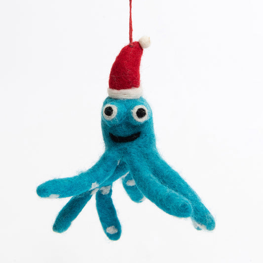 A Christmas decoration pictured on a white background. The decoration is a felt blue octopus wearing a red Christmas hat, smiling.