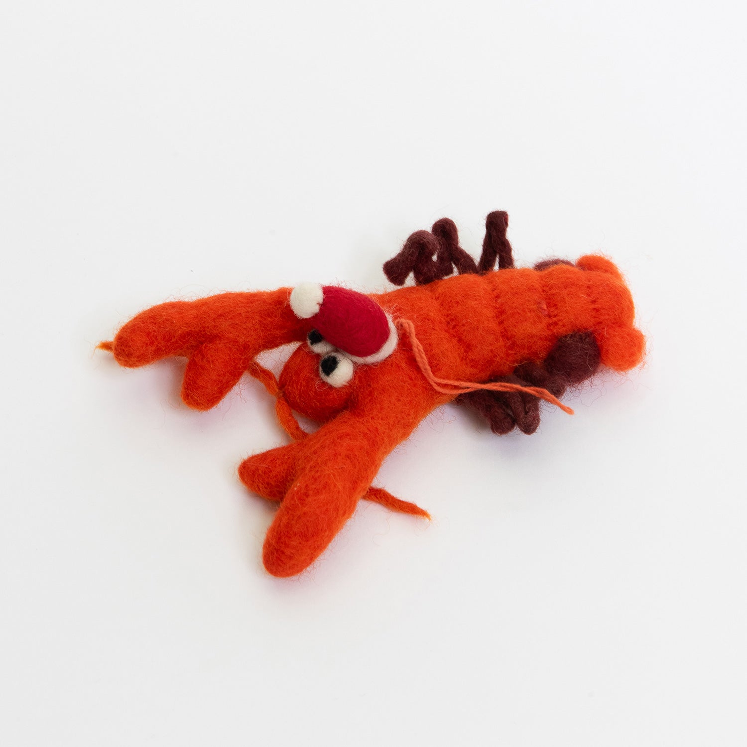 A Christmas lobster decoration on a white background. The decoration is an orange felt lobster wearing a red Christmas hat.