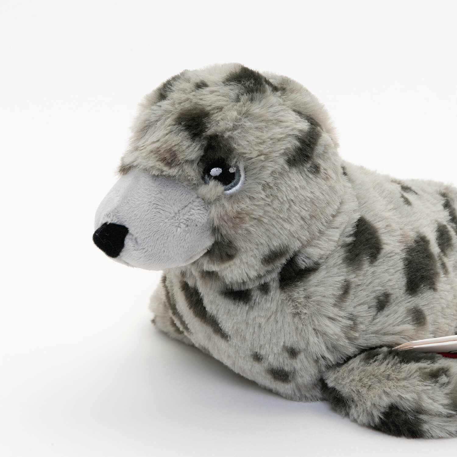 close up of eye and nose of light and dark grey spotted plush seal