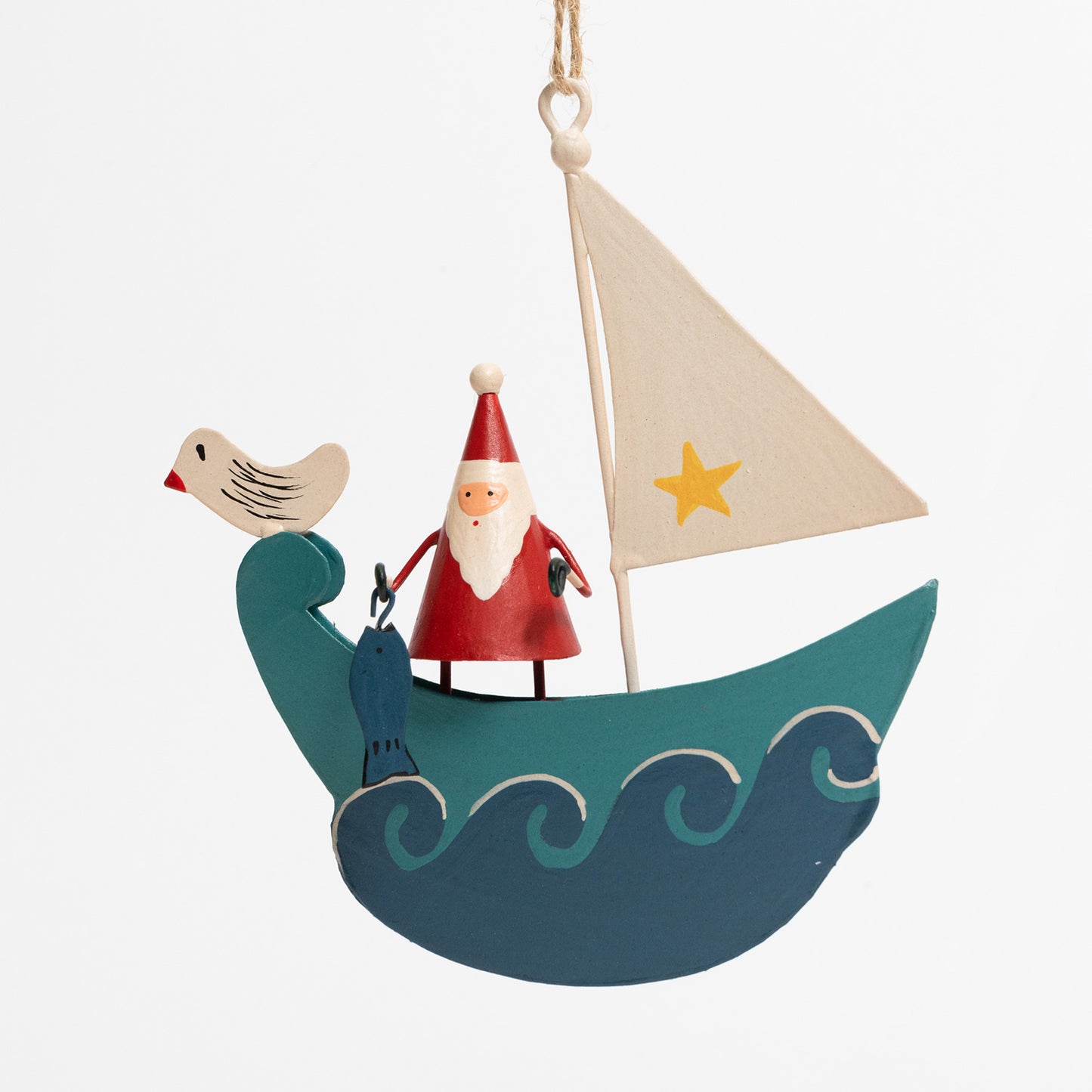 A Christmas decoration pictured on a white background. The decoration is Santa standing on a blue sailboat with blue waves lapping up around it. There is a seagull sat on the front of the ship, and Santa is holding a fish.