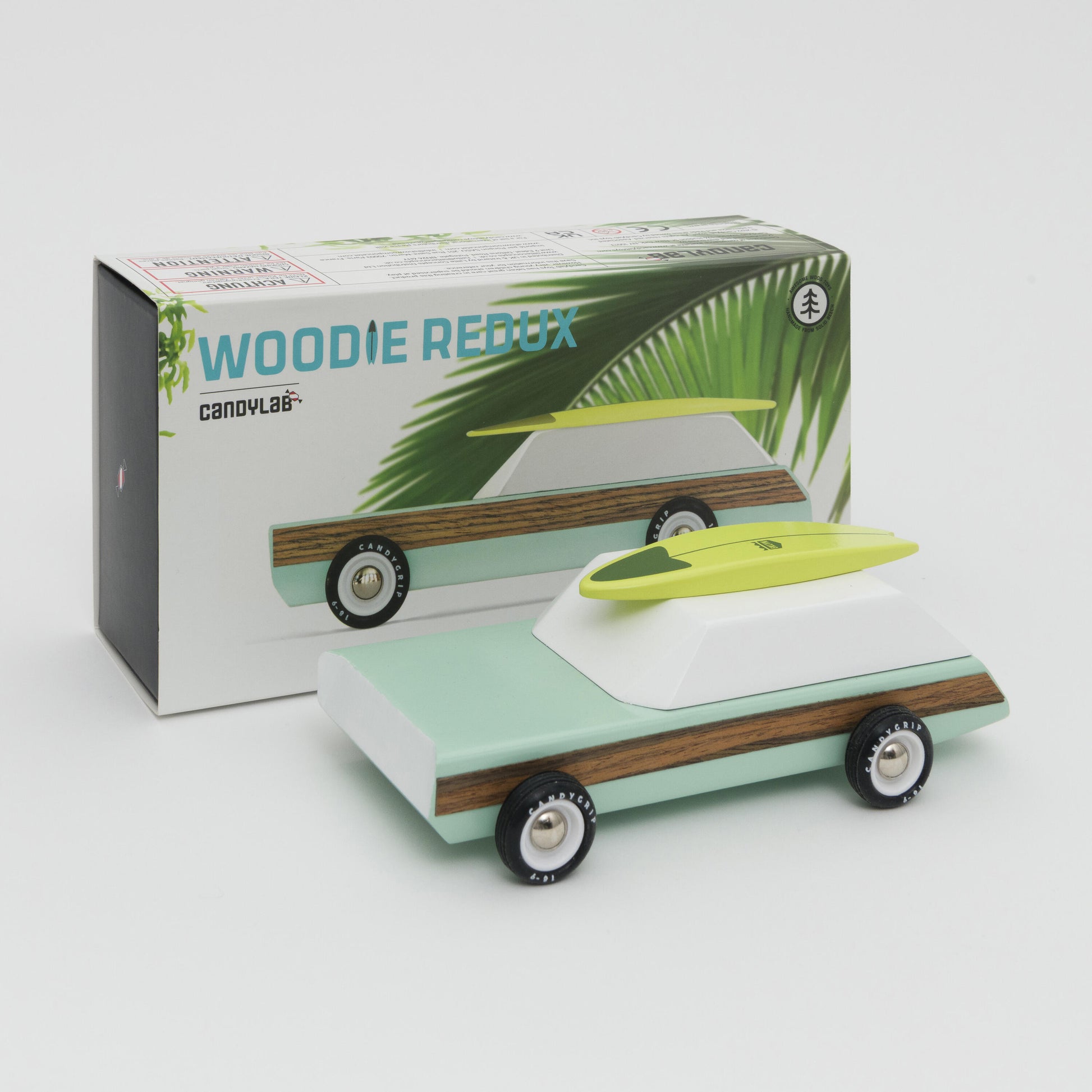 Shot of mint green and white wooden car with wooden surfboard on the roof. Shot in front of its box