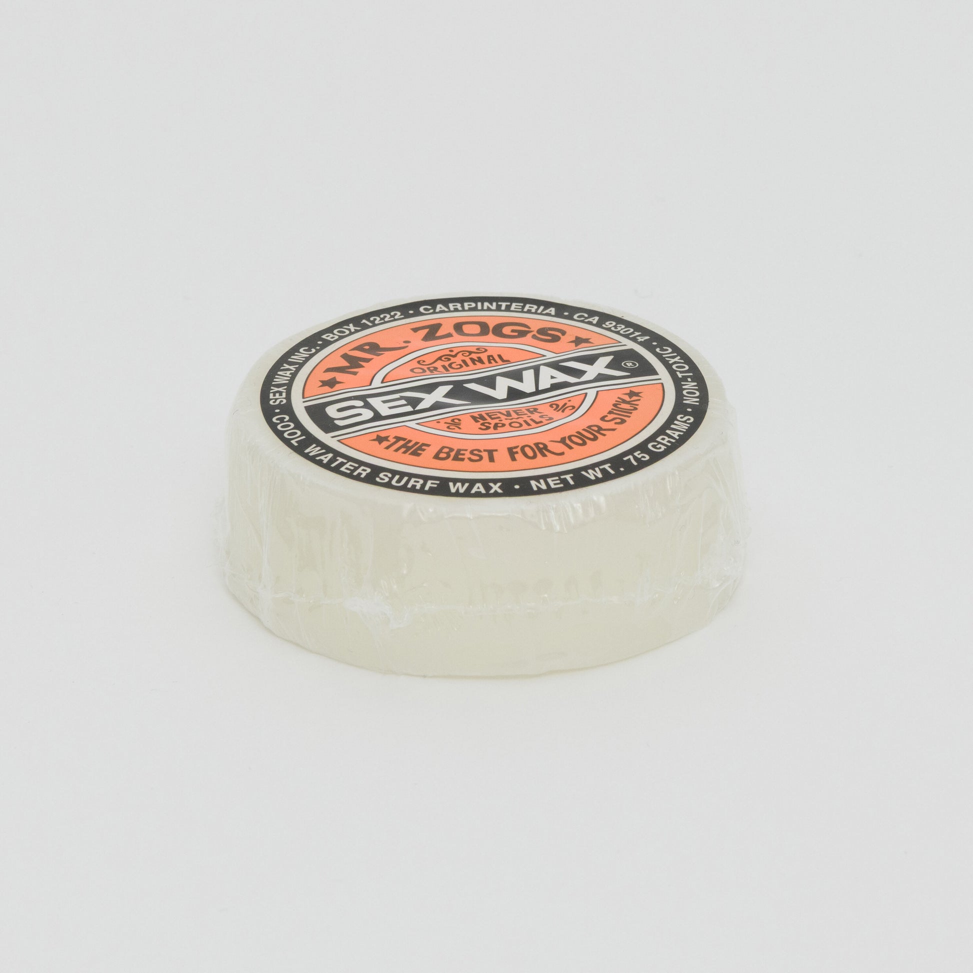Image shows a clear disc of surfboard wax with orange Sex Wax branding