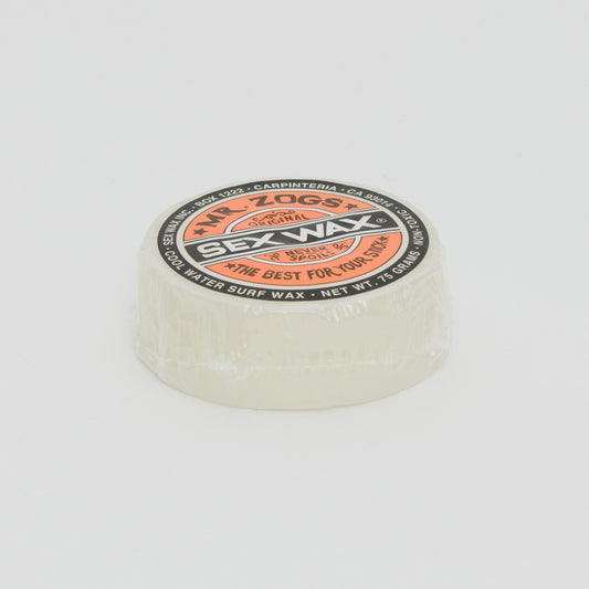 Image shows a clear disc of surfboard wax with orange Sex Wax branding