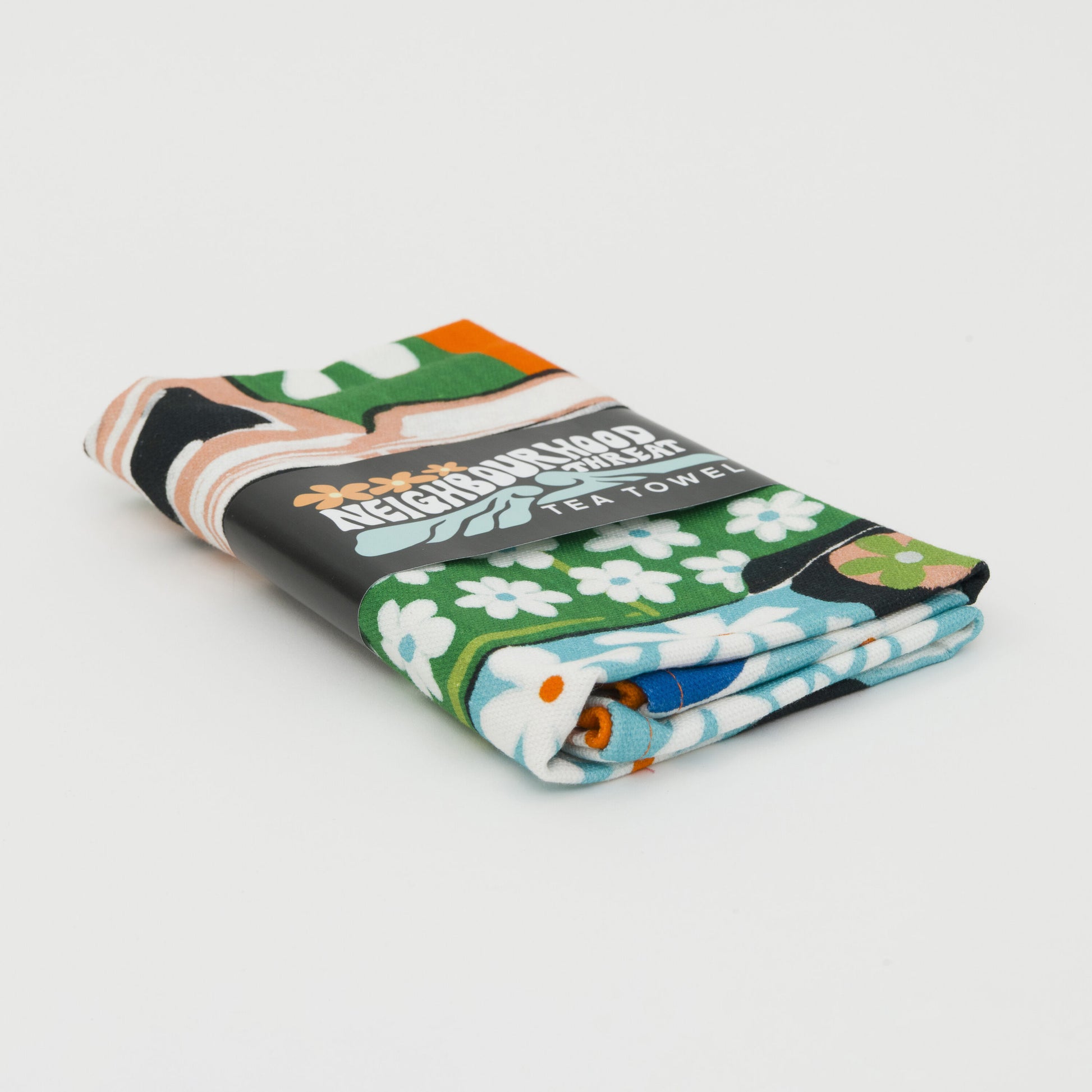 Tea towel folded up and wrapped in its paper bellyband packaging.