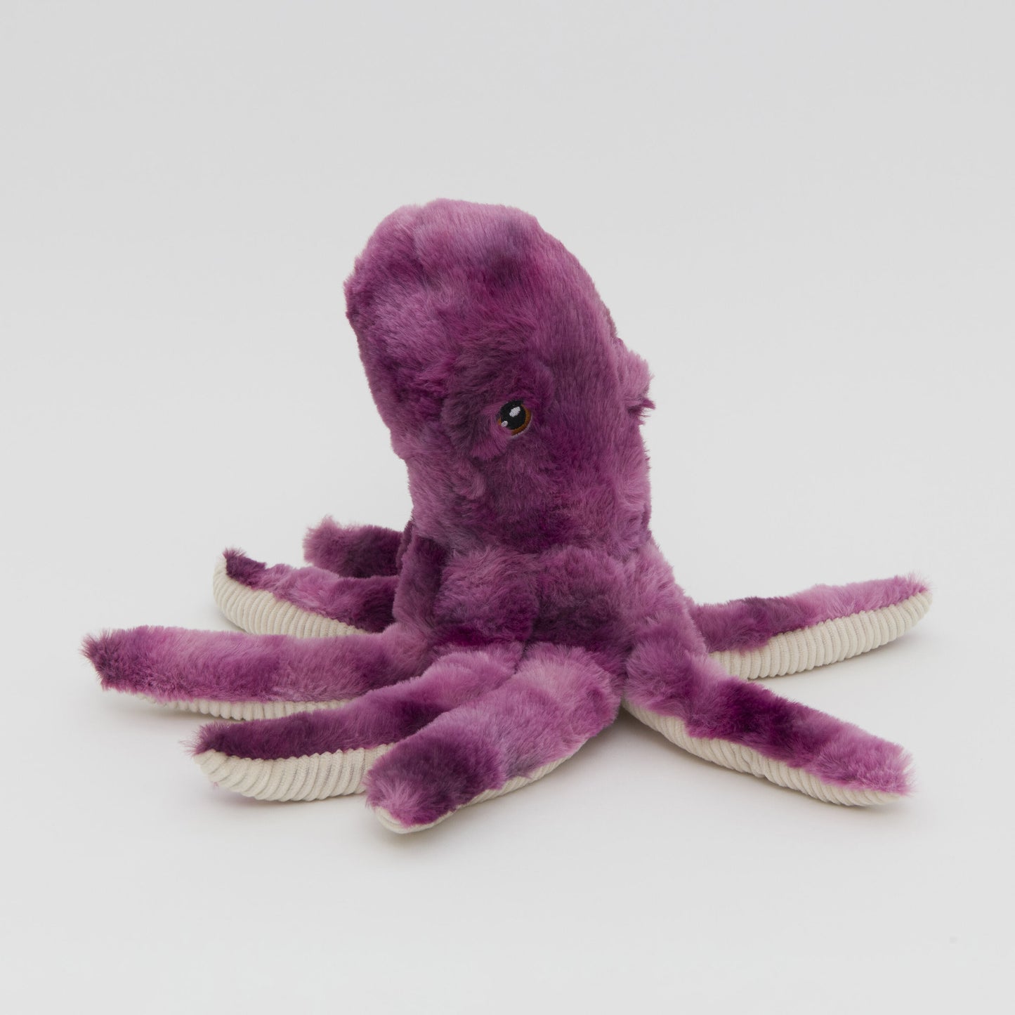 A photograph of a plush purple octopus toy with soft, fluffy texture and contrasting white tentacle tips against a plain white background.