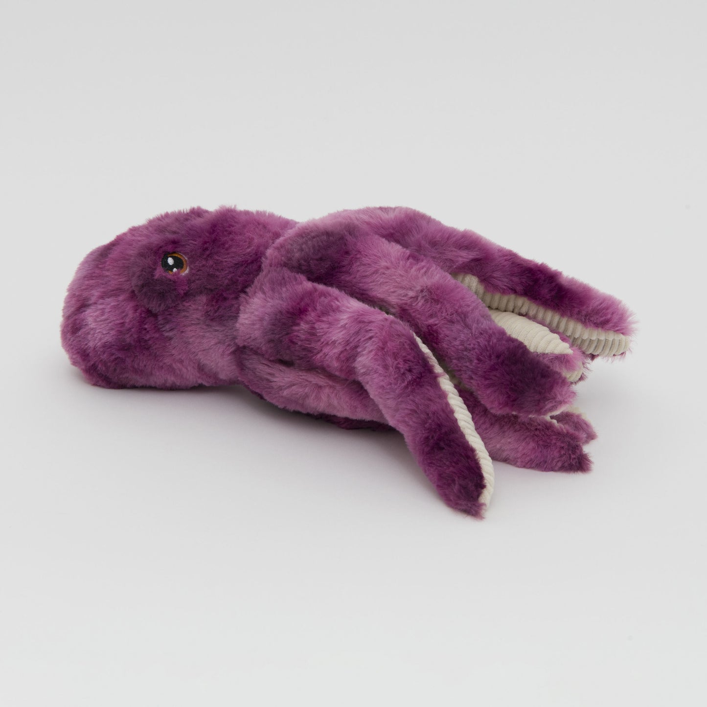 A photograph of a plush purple octopus toy with soft, fluffy texture and contrasting white tentacle tips against a plain white background.