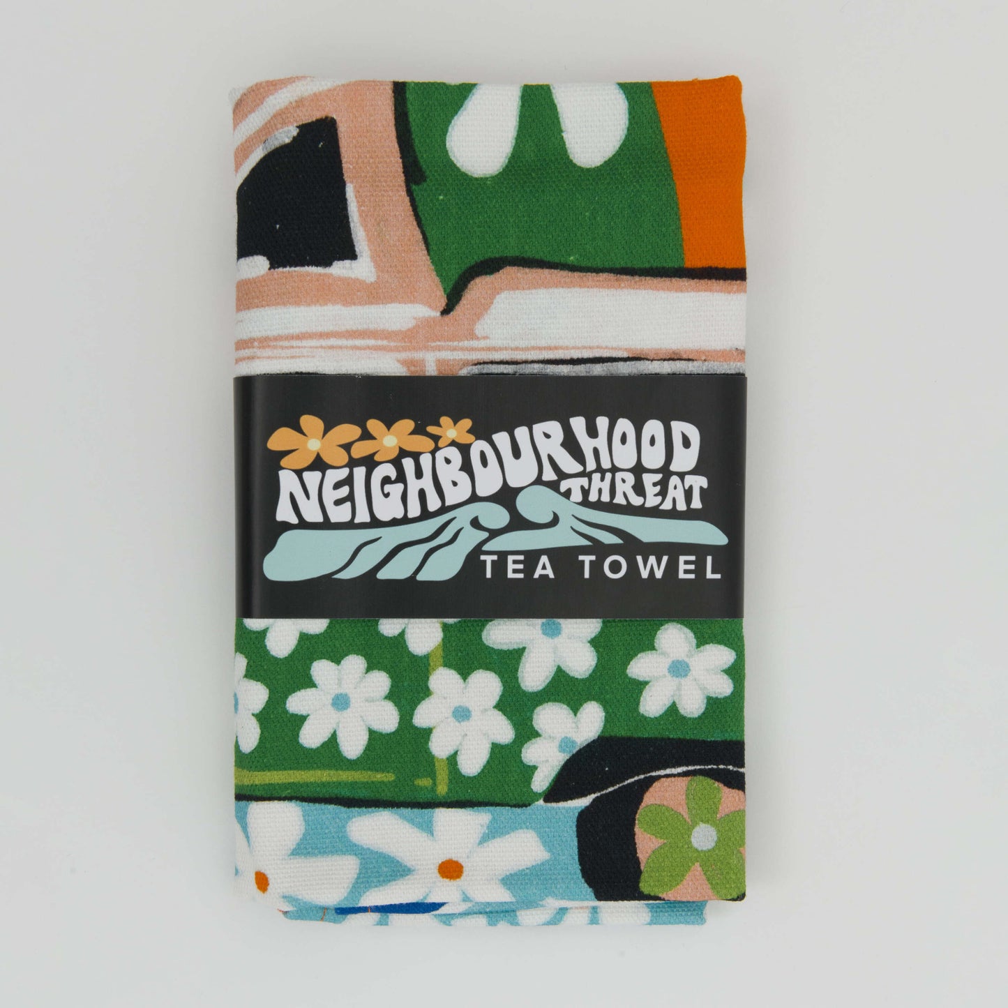 Tea towel folded up and wrapped in its paper bellyband packaging.