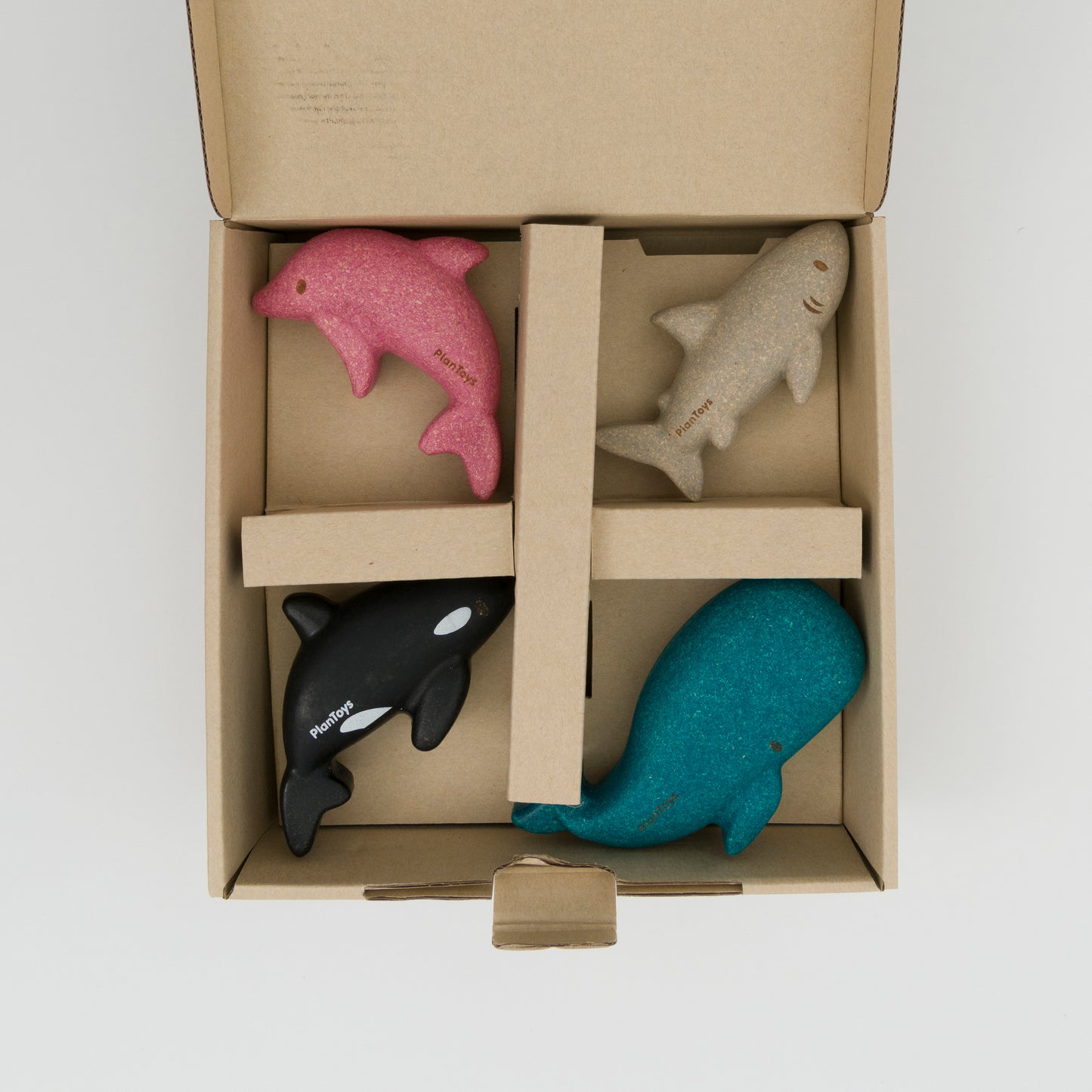 Cardboard box packaging showing 4 ocean animal toys, pink dolphin, grey shark, black orca, blue whale.