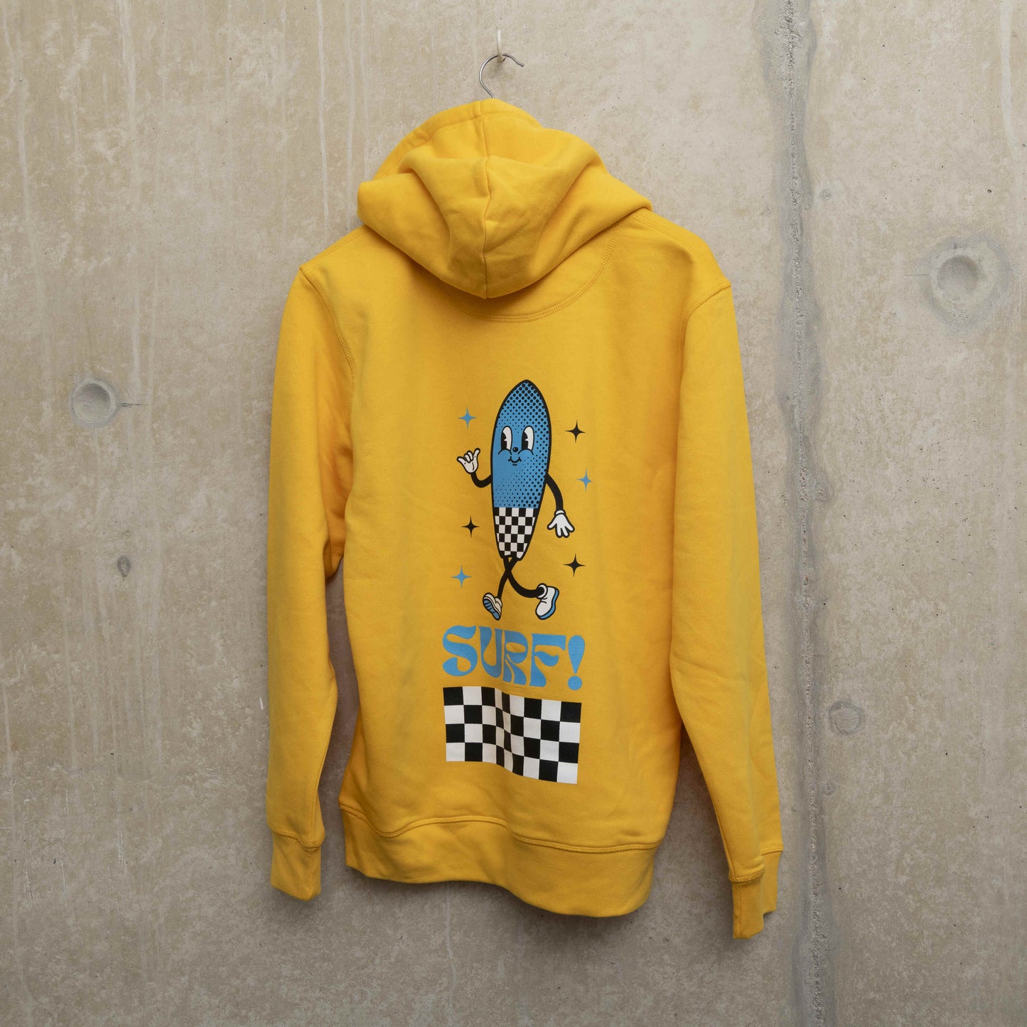 Sot of the back of the yellow hoodie with character printed large on the back of the garment. Character is shaped like a surfboard in blue with black and white checkerboard design, with the word Surf underneath.