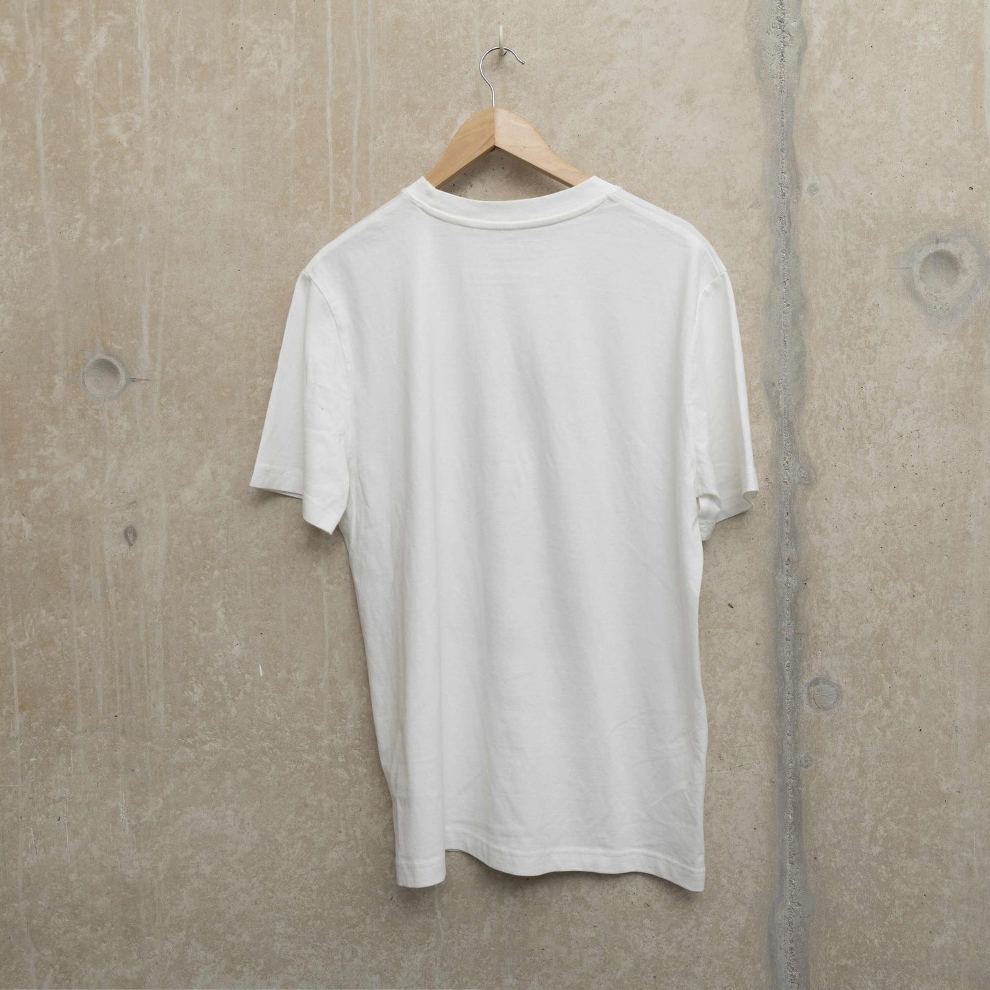 Shot of back of the white t-shirt with nothing printed on it.