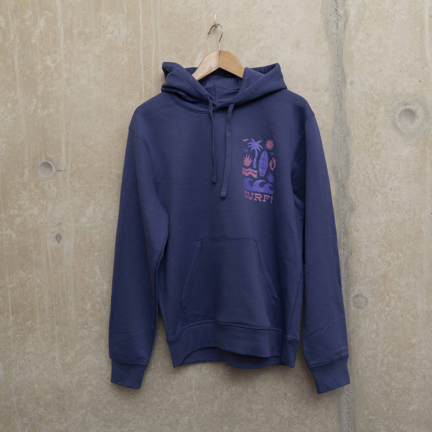 Purple hoodie on a hanger, with surf motif in light purple and pink on left chest. Motif shows waves, foot prints, surfboard, sun and palm tree.