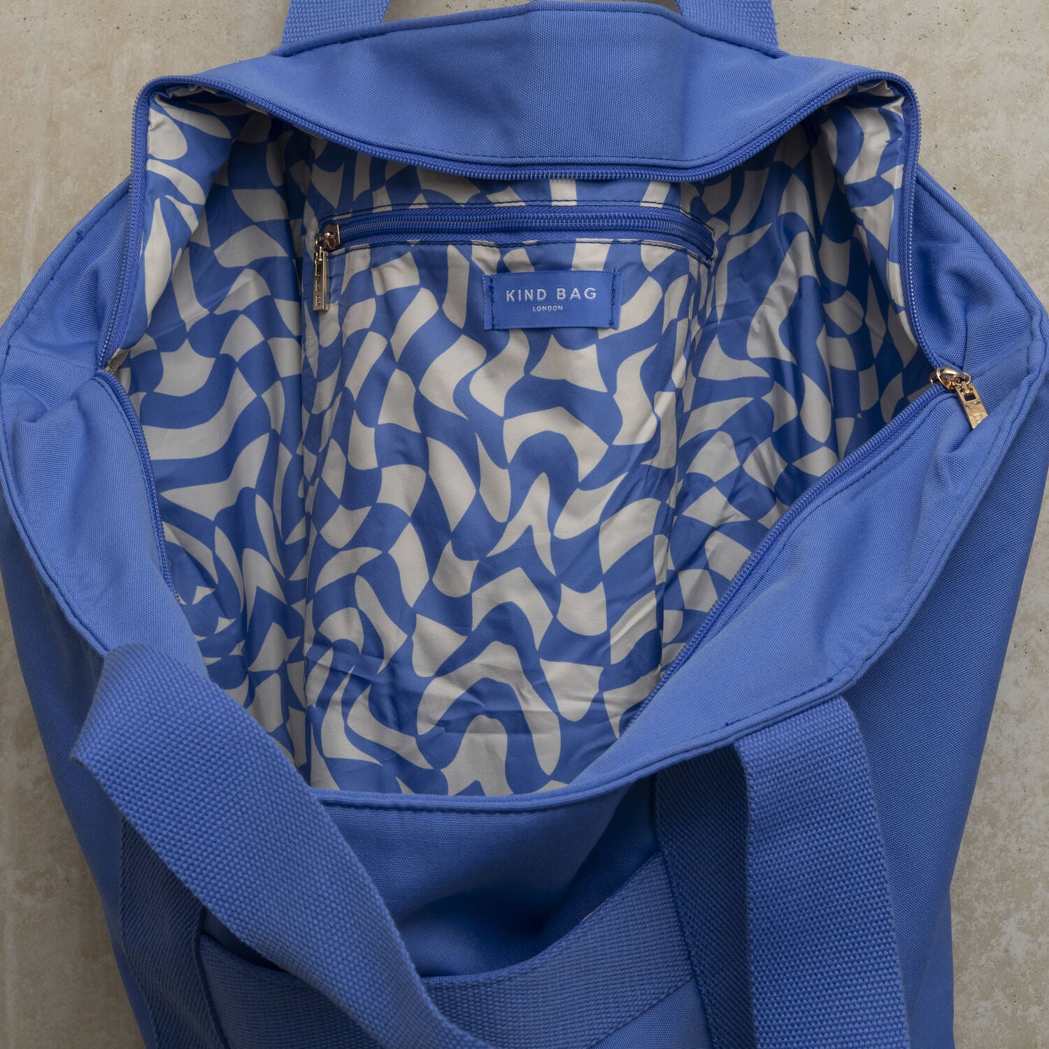 Showing the inside of the blue tote bag with blue and white wavy checkerboard pattern