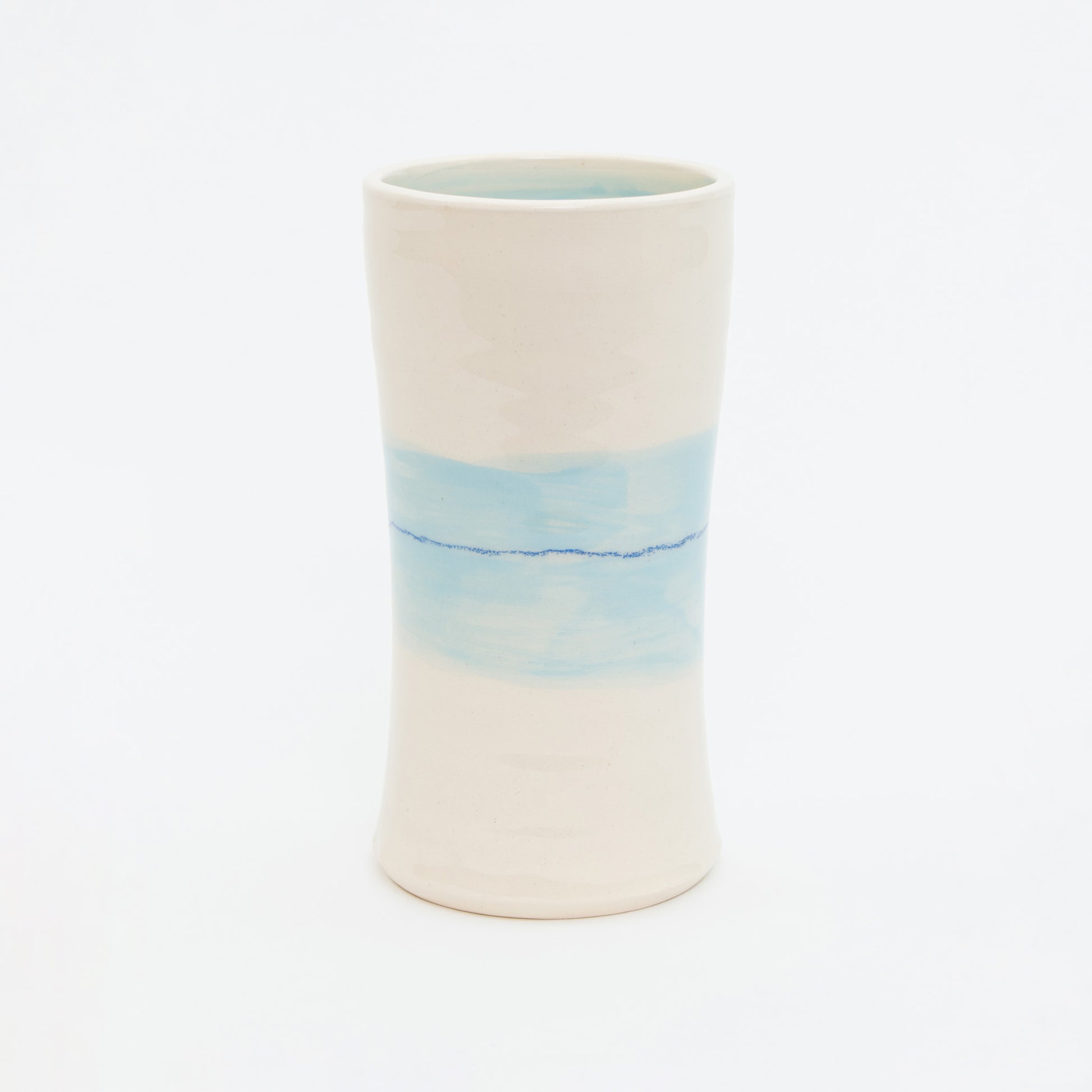 Ceramic vase with a gradient design from white to blue on a white background.