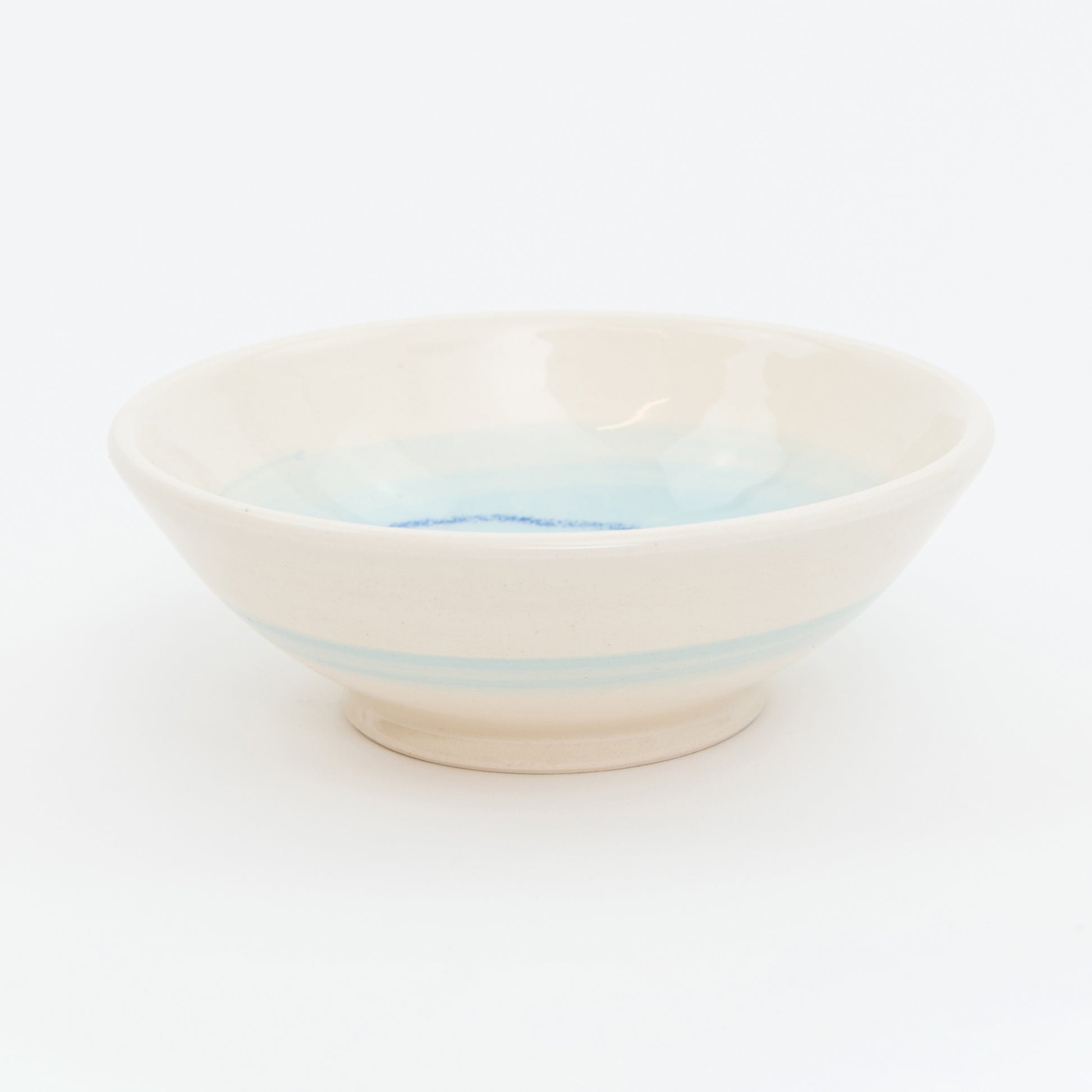Ceramic bowl with light blue stripes on a white background