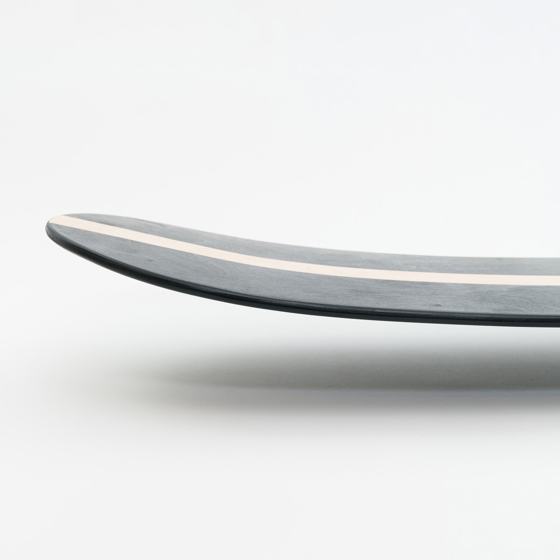 Close-up of a curved wooden bellyboard on a white background