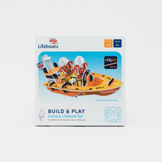 RNLI Inshore Lifeboat Playset. Press, Build & Play set in compact cardboard box. Two playboard RNLI team members in their yellow waterprroofs and life vests. Inside their fully buildable playboard RNLI dingy boat.