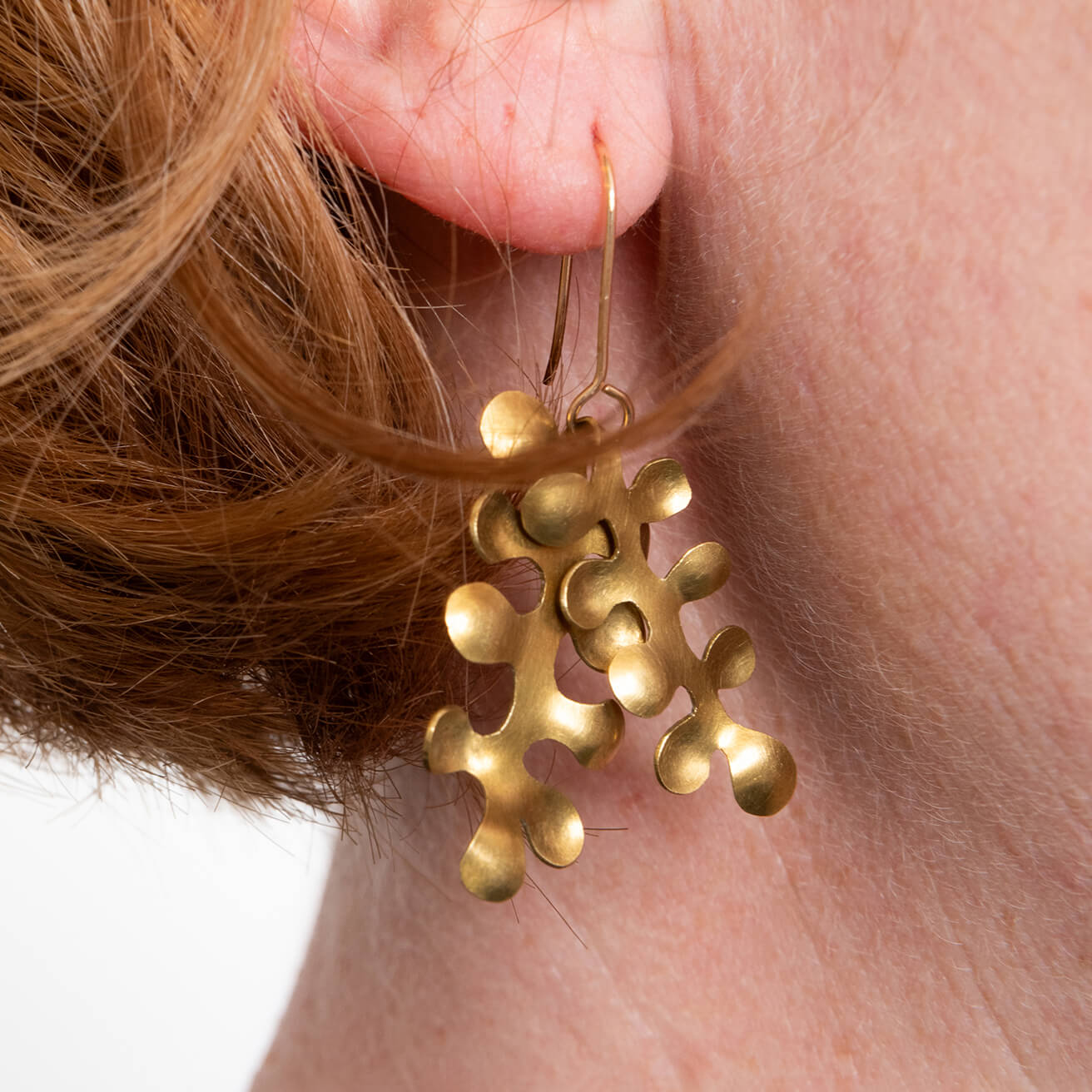 Close up of brass seaweed bubble earrings