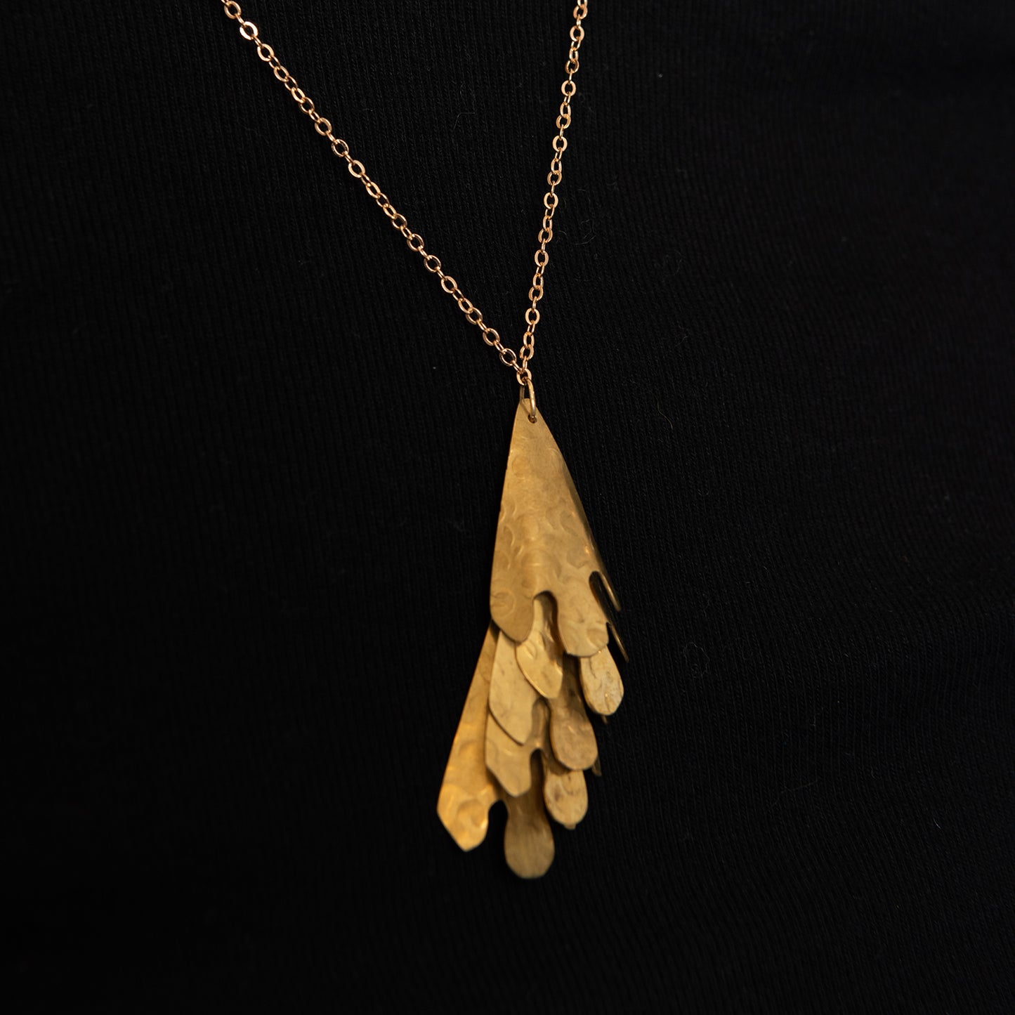 close up of brass cascade necklace showing 5 layers