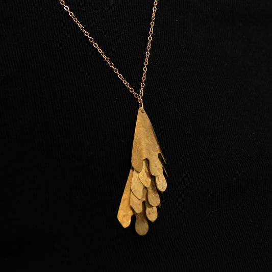 close up of brass cascade necklace showing 5 layers