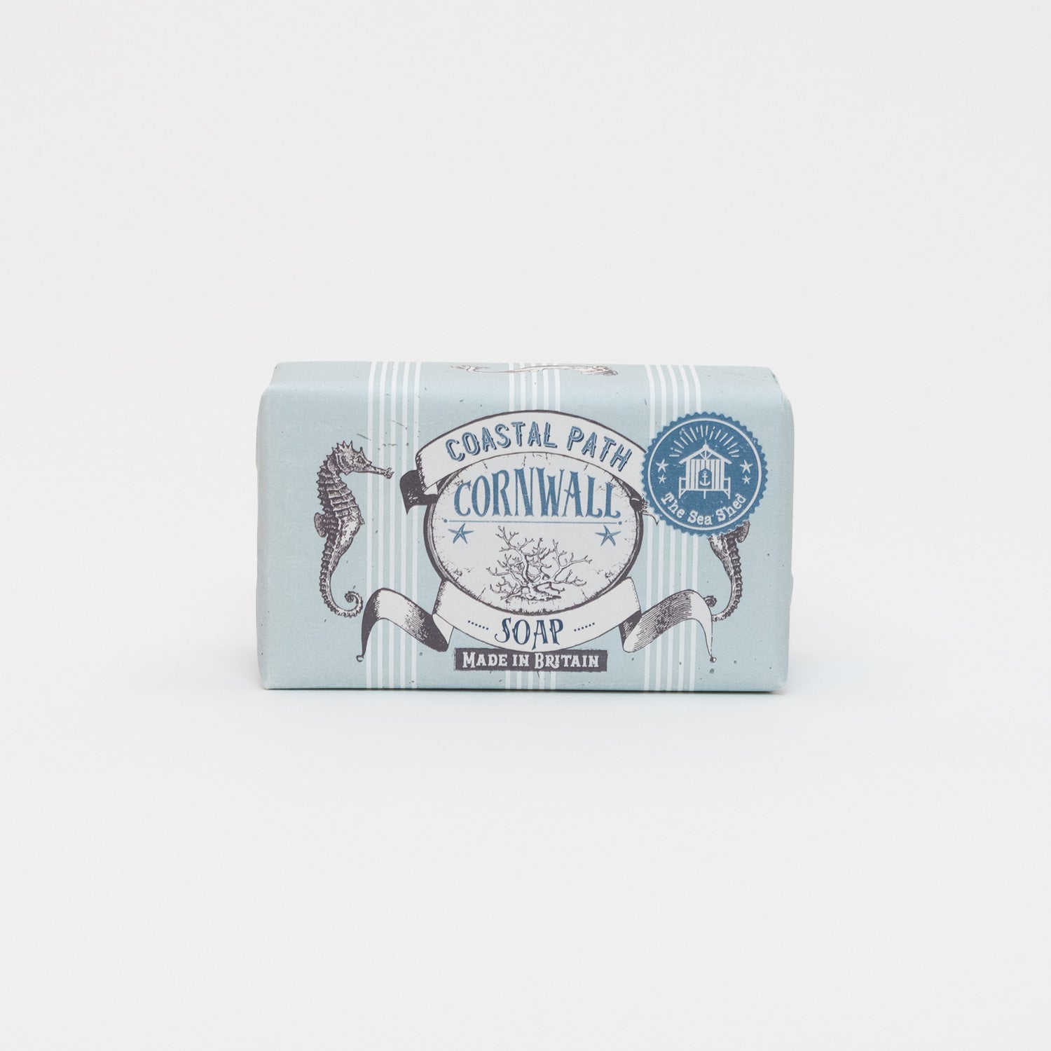 A photo of packaged coastal path soap on a white background. The soap has blue and white packaging with illustrations of seahorses and seaweed.