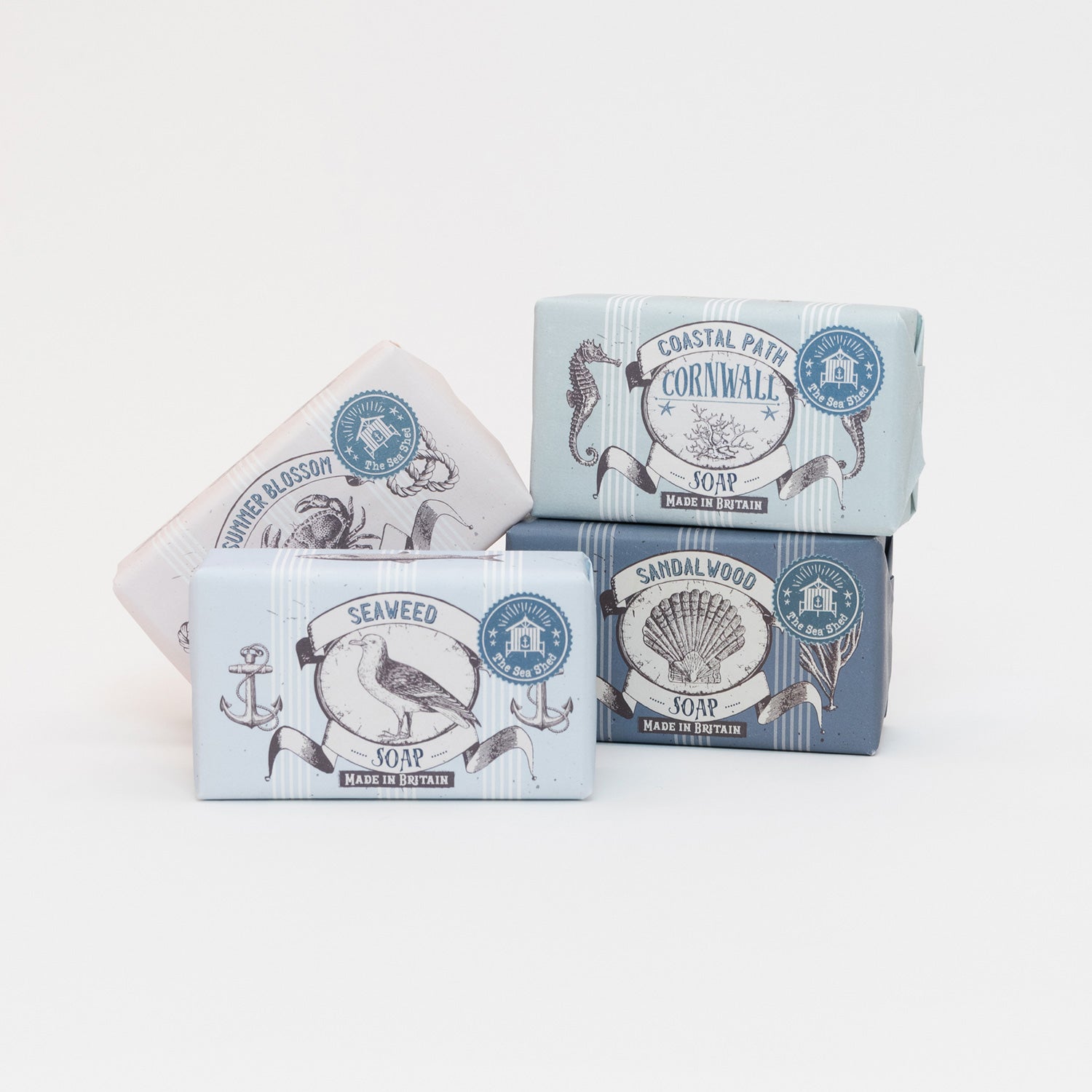 Four variants of soap stacked on top of each other: Seaweed, Sandalwood, Coastal Path, and Summer Blossom.