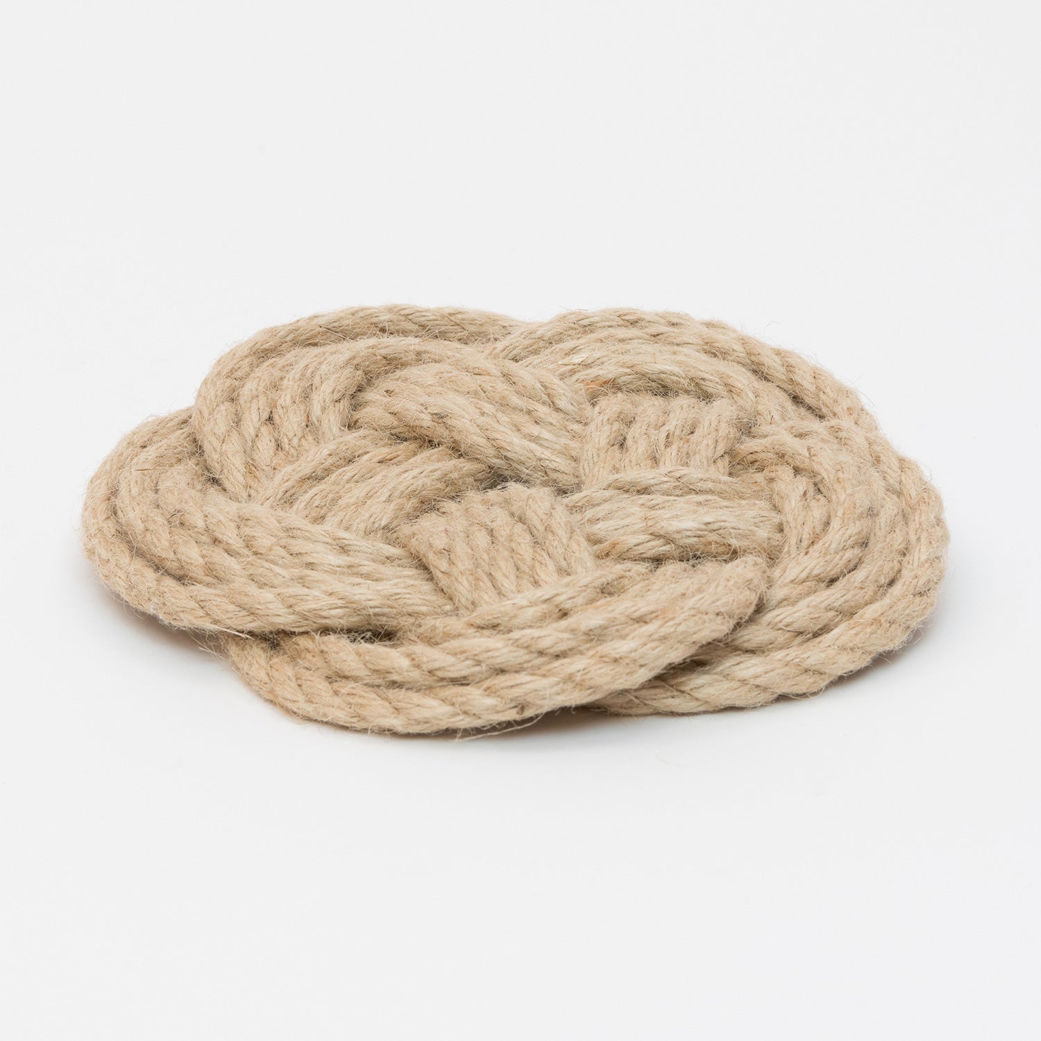 Light brown knotted rope trivet in a circular shape.