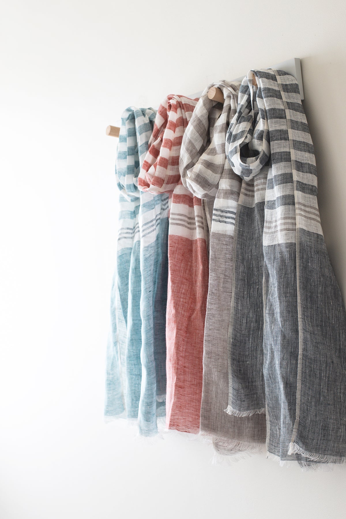 4 linen scarves hanging on hooks