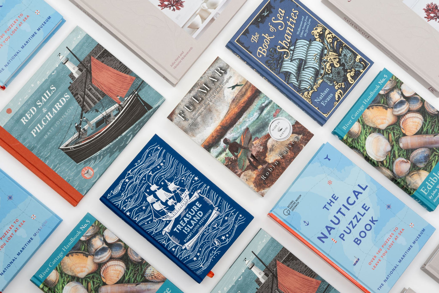 A collection of maritime-themed books arranged on a white surface. 