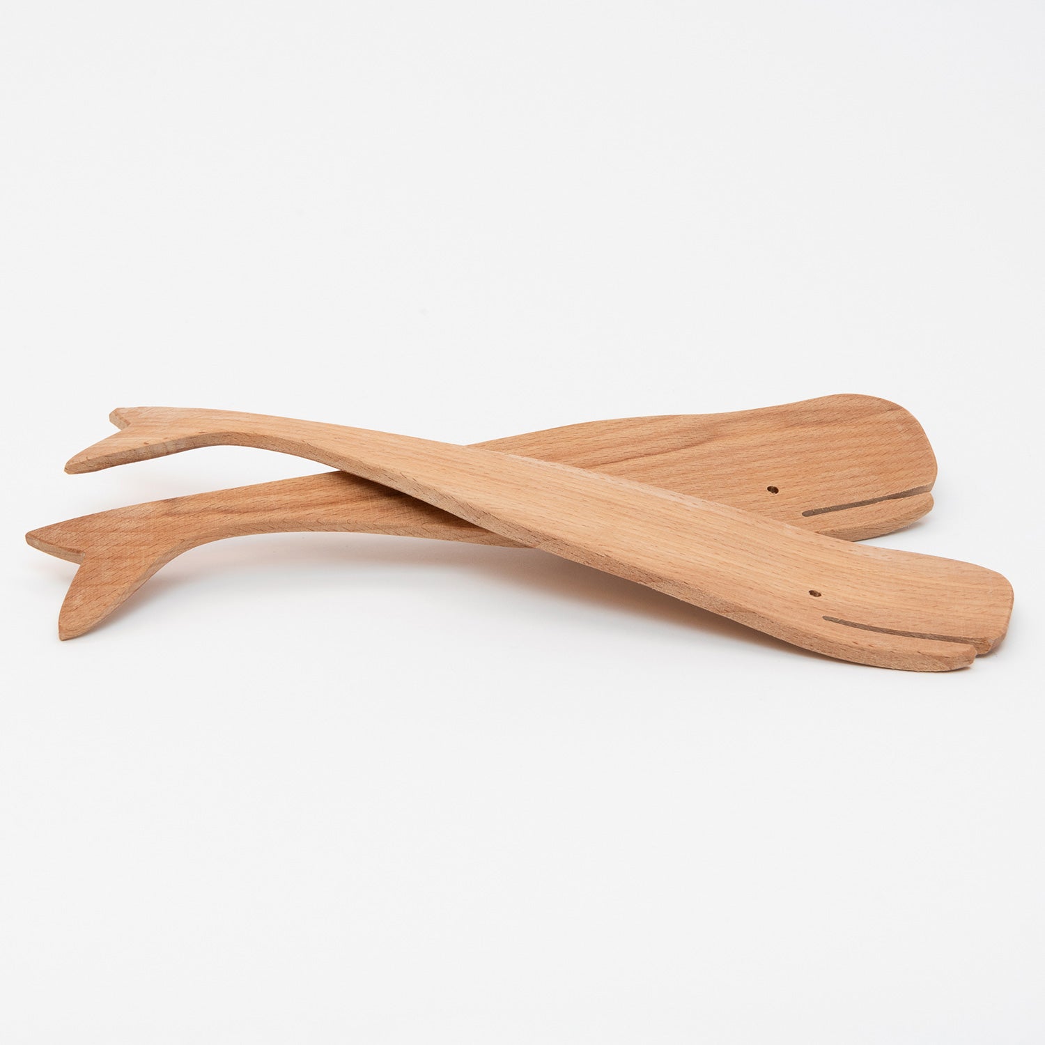 Two wooden salad servers in the shape of a whale. Pictured on a white background.