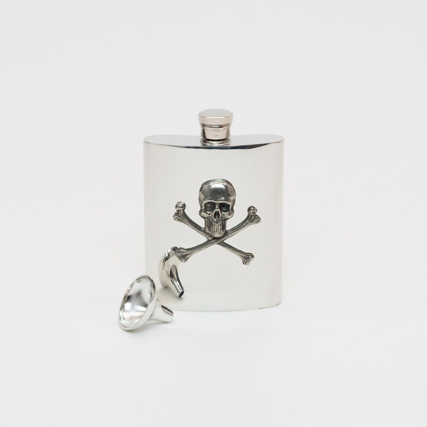A silver hip flash with a silver skull and cross bones detail. The hip flash is displayed with the small funnel that comes with it.