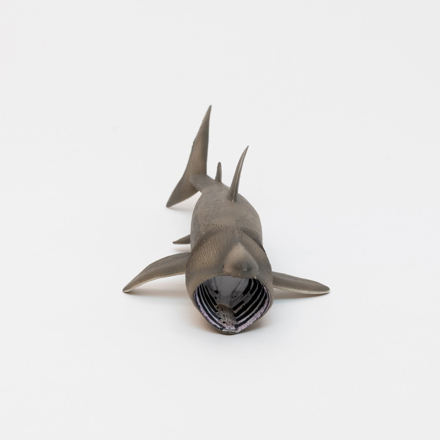 A basking shark plastic toy on a white background.