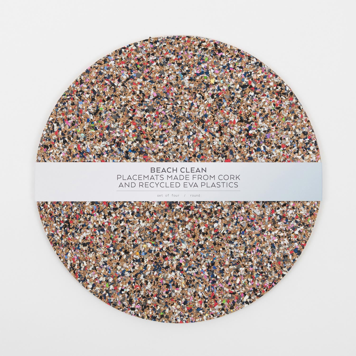 A top down view of the Beach Clean Placemat Set with the packaging strip going across the middle of the circular placemats.