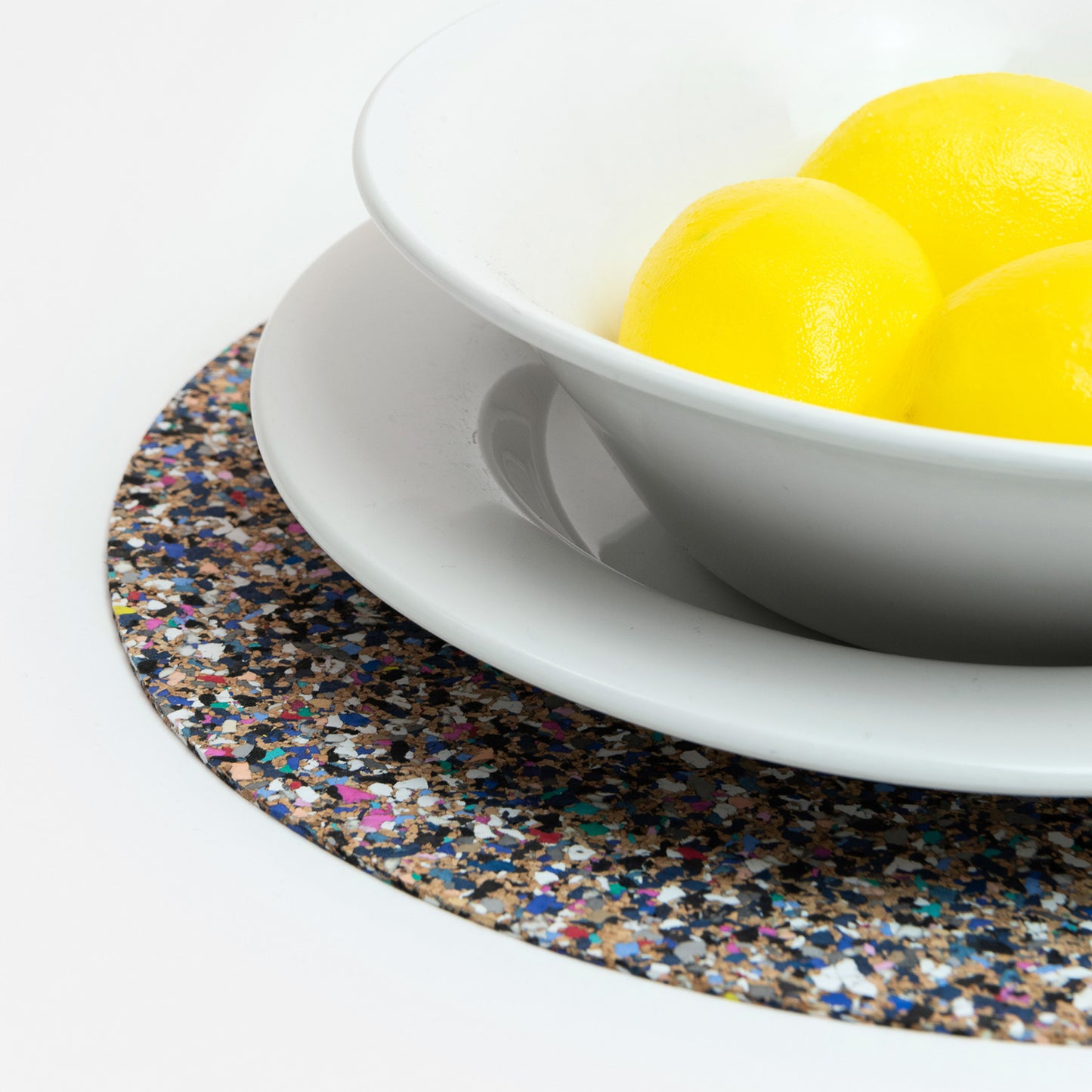 The Beach Clean Placemat with a white bowl on top holding three lemons.
