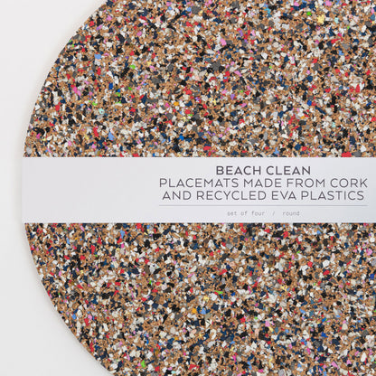 Close-up top down view of the Beach Clean Placemat Set with the packaging strip going across the middle of the circular placemats.