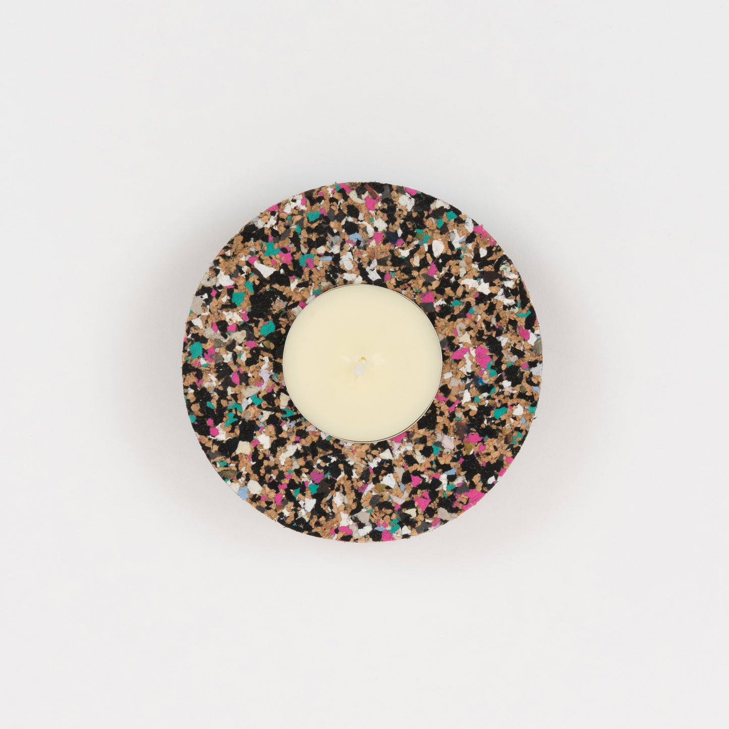 A top down view of the Beach Clean Tea Light Holder. The Tea Light Holder is multi-coloured and is holding a cream coloured tea light.