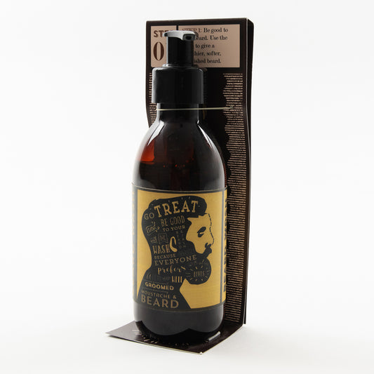 A bottle of beard wash pictured on a white background. It's a dark brown bottle with a white and yellow label. The label features an illustration of a man's face in profile with a large beard.