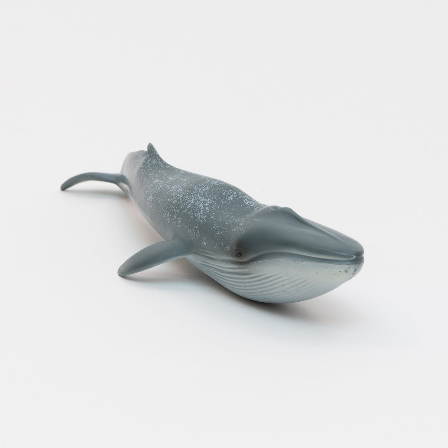 A blue whale plastic toy on a white background.