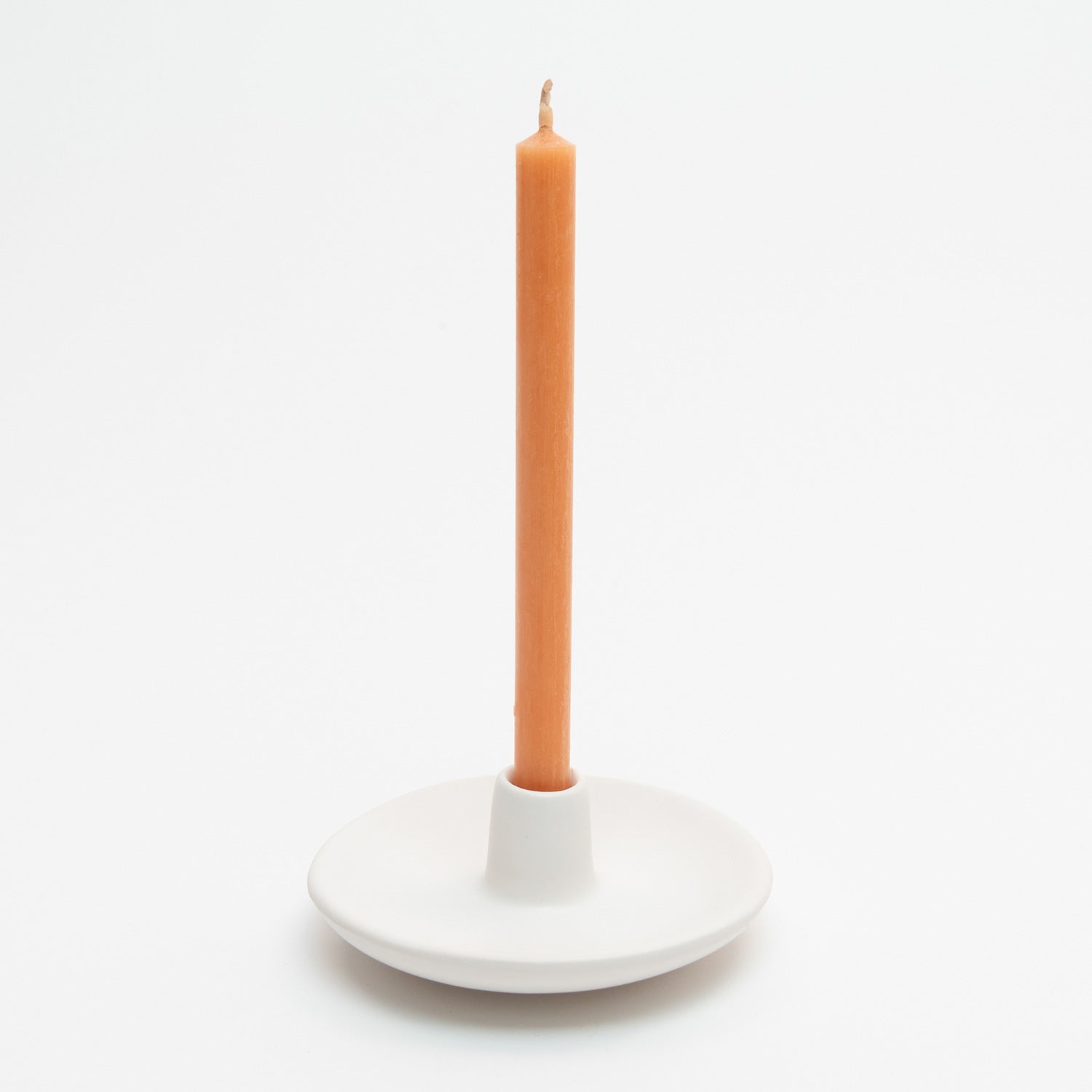 St Eval Mini Candle Holder. Small ceramic white dish with holder protruding up from centre, containing a St Eval Orange and Cinnamon Candle.