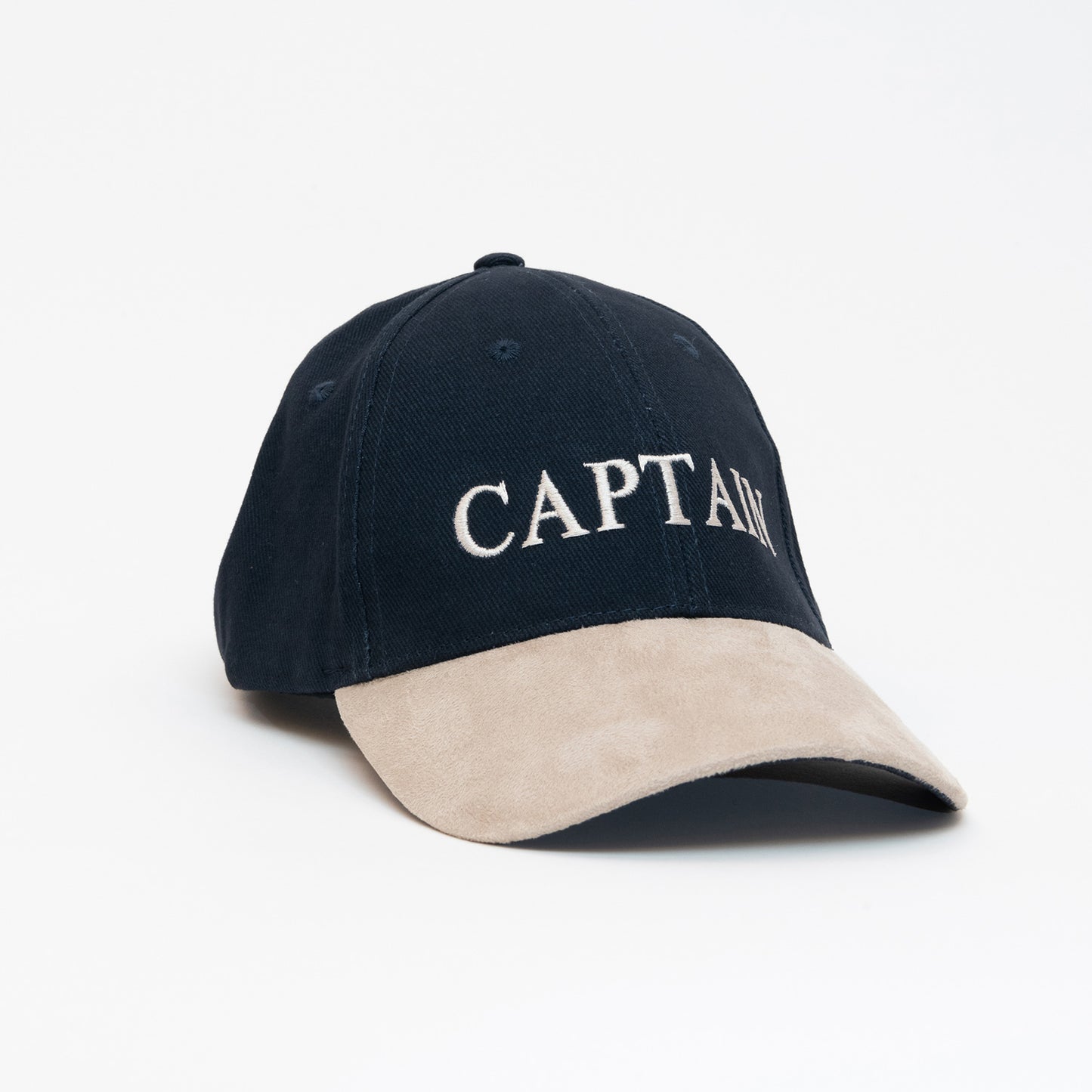 A black cap with a beige peak, with the word 'Captain' written on the front. Photographed on a white background.