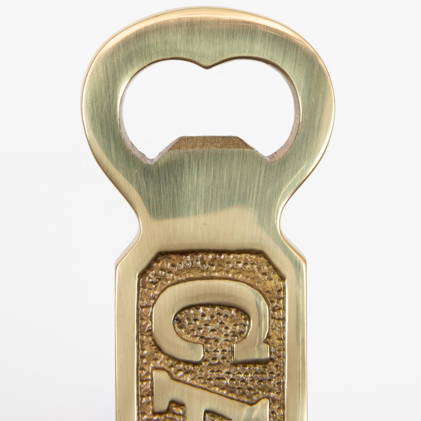 A close-up of a solid brass bottle opener with 'Captain' written on it. Photographed on a white background.