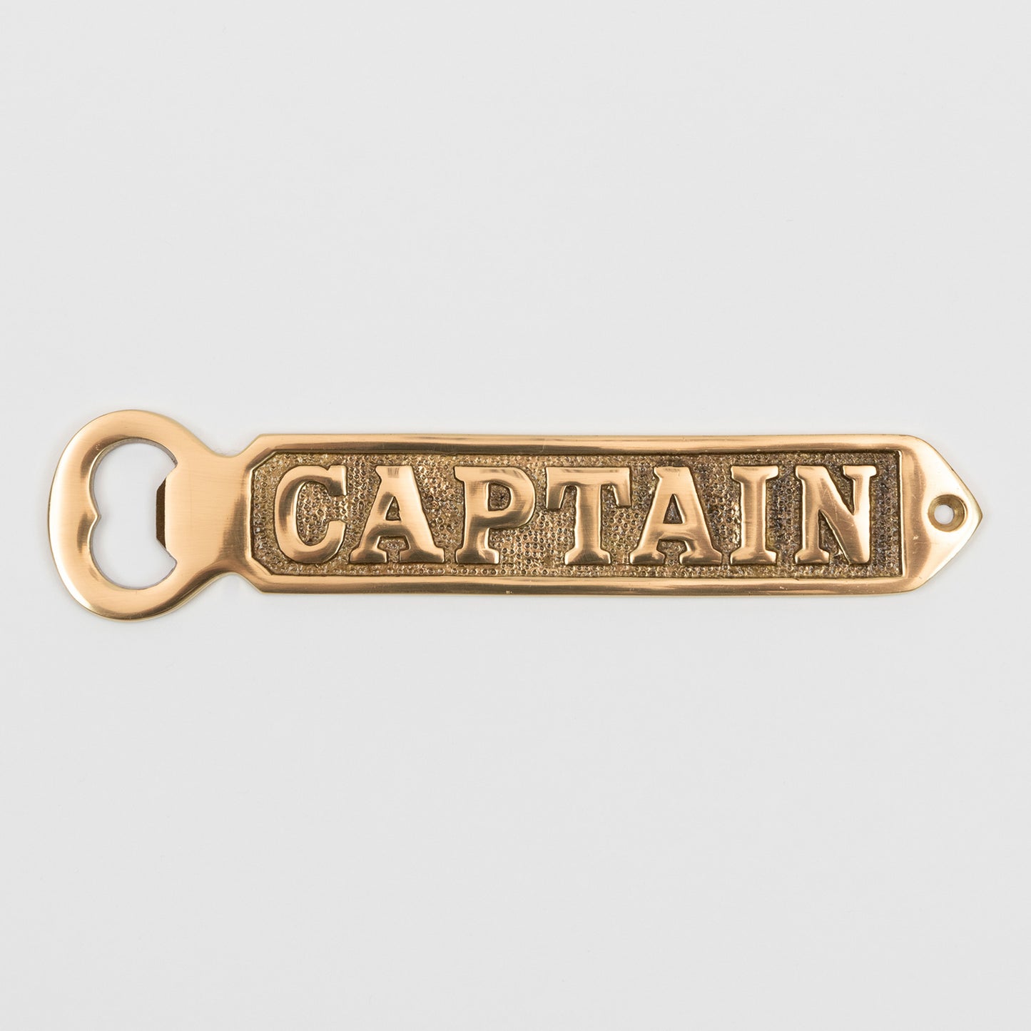 A solid brass bottle opener with 'Captain' written on it. Photographed on a white background.