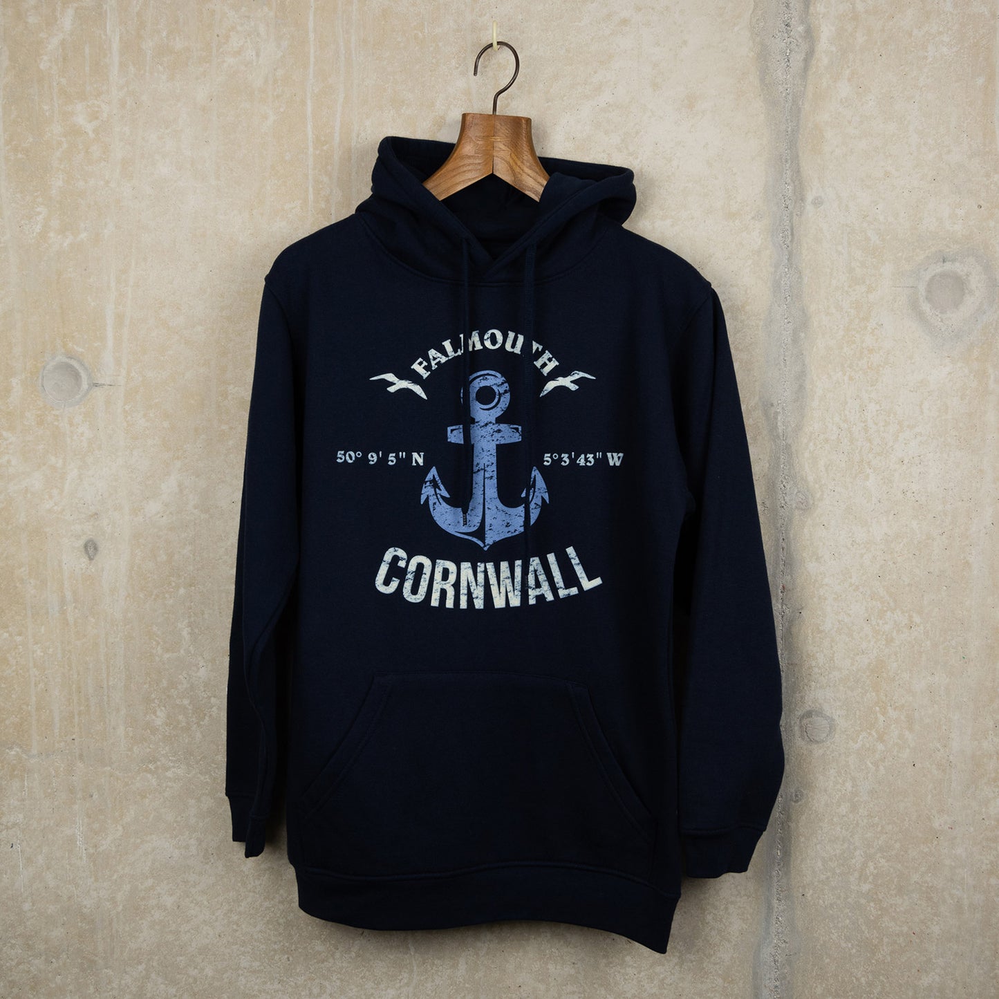 Navy hoodie with bespoke design made for the museum. Falmouth Cornwall in white writing around a distressed blue anchor