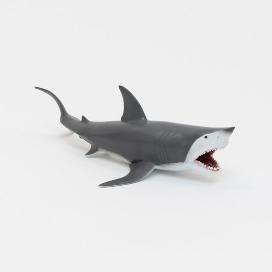 A plastic great white shark toy on a white background.