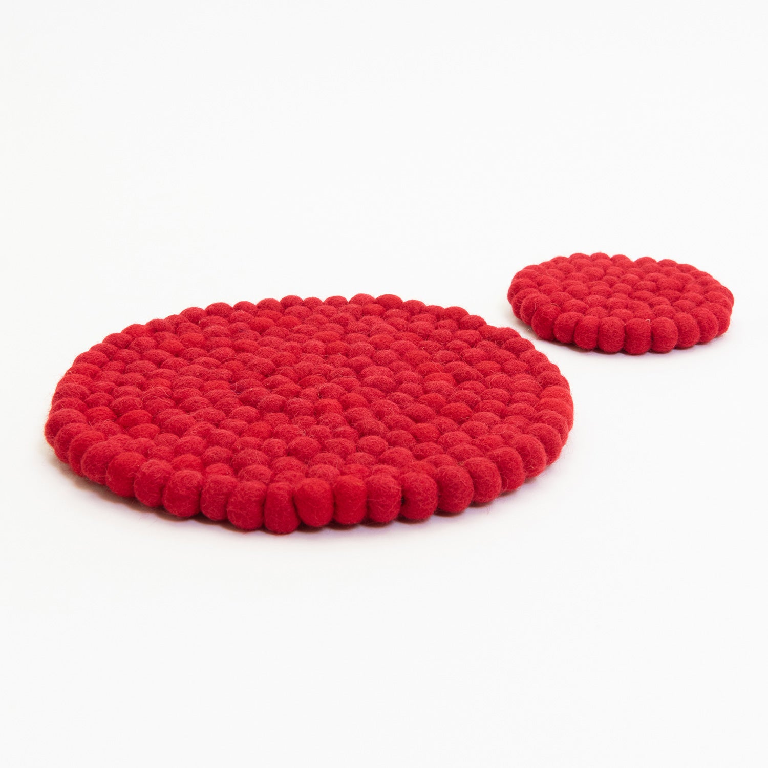 A red felt ball trivet and a red felt ball coaster pictured on a white background.