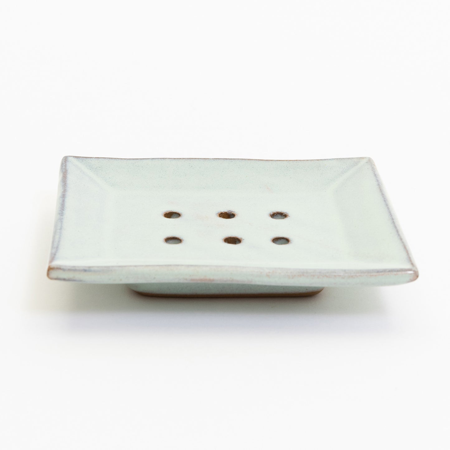 A stoneware soap dish in ice blue colour. Pictured on a white background.