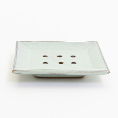 A stoneware soap dish in ice blue colour. Pictured on a white background.